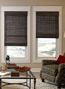 Vignette showing two grey natural Roman shades in a living room